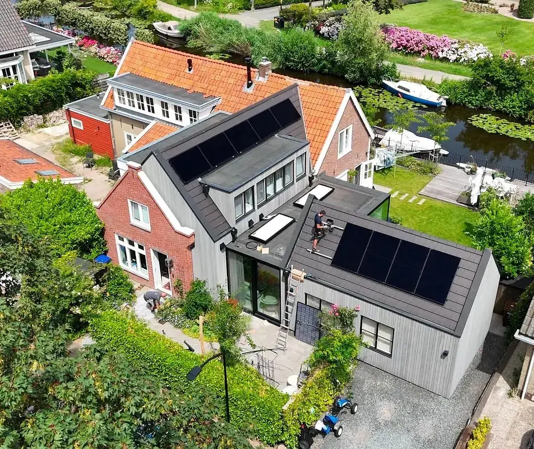Elektricien van SunCharged legt zonnepanelen op een dak